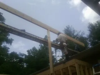 Carpenter setting a ridge beam over a new addition frame — Ice Dam Removal by Roofing Brothers in Kincaid
