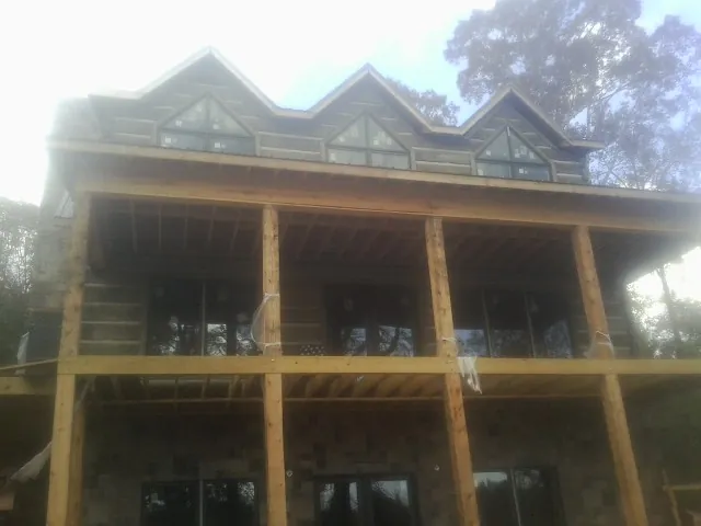 Dormers and porch framing on a large log home under construction — Roof Coating work by our crew in Kincaid