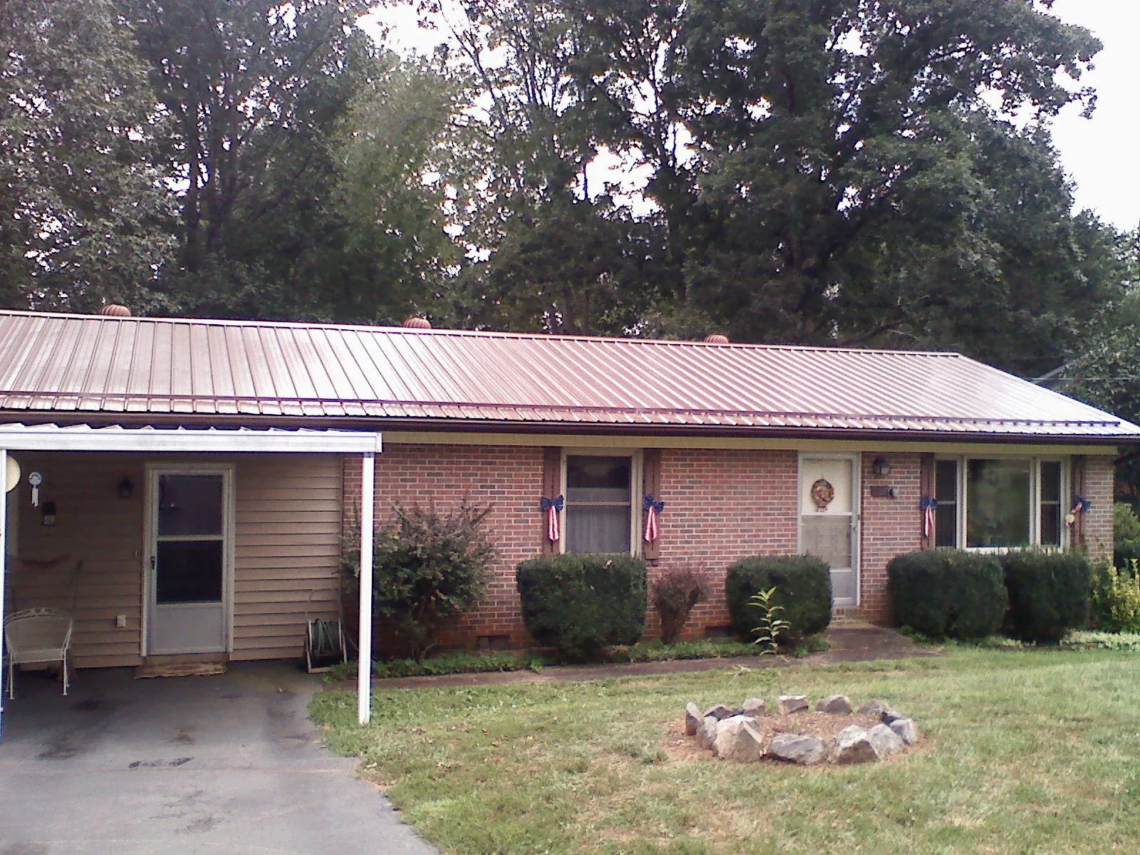 Bronze metal roof and carport on a brick ranch home — Roof Repair work by our crew in Kincaid