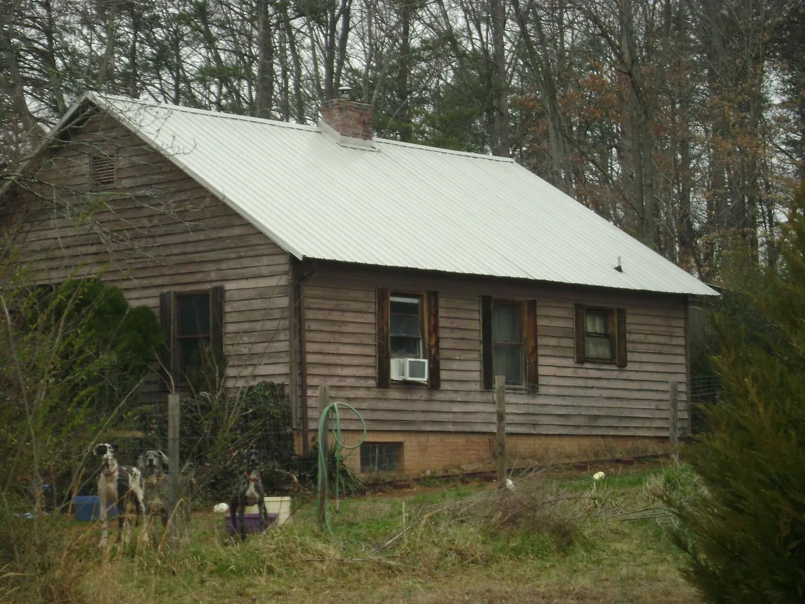 White metal roof on an old wood sided farmhouse, from a Metal Roof Installation job in Kincaid